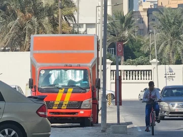 شاحنة نقل سيارات مغلقة ومؤمنة في شوارع إحدى العواصم الخليجية لخدمة الشحن الدولي.